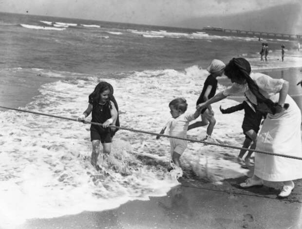 В начале XX века не было надувных матрасов, нарукавников и плавательных кругов. Поэтому дети купались с помощью специальных канатов, обеспечивающих некую безопасность. Пляж в Трувиль, Франция, 1913 год.