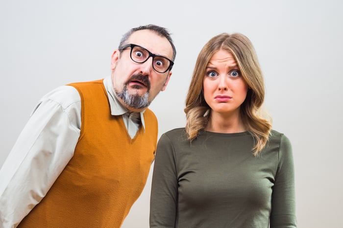 A couple is looking shocked and not happy.