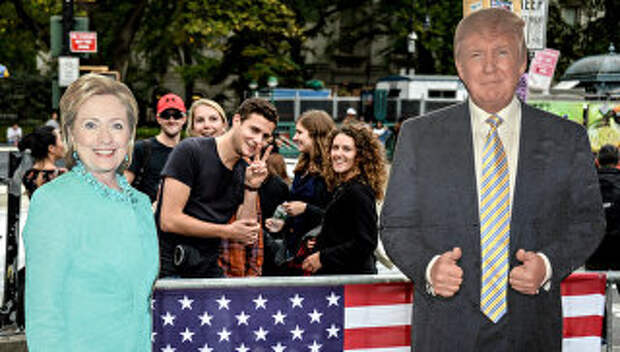 Молодые люди рядом с ростовыми фигурами кандидатов в президенты США в Нью-Йорке