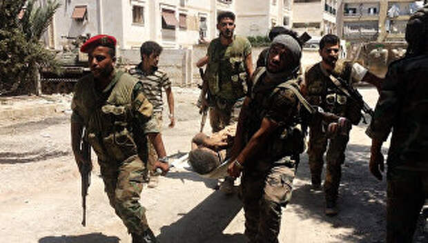Бойцы сирийской армии выносят раненого на юго-западе Алеппо. Архивное фото