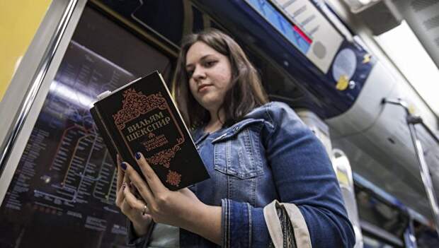 Девушка читает книгу Уильяма Шекспира в поезде московского метро