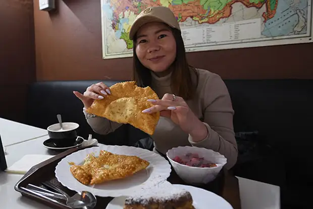 Человек ест чебурек