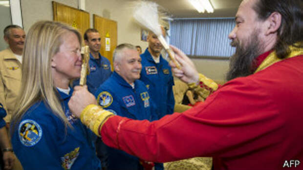 Отец Сергий - настоятель храма в Байконуре - благославляет астронавта НАСА перед полетом