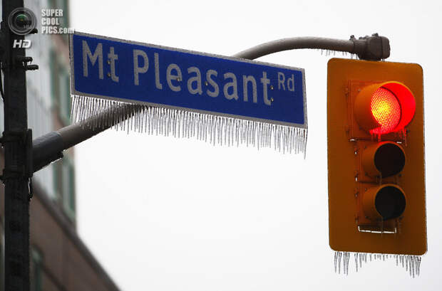 Канада. Торонто, Онтарио. 22 декабря. Сосульки на светофоре и дорожном знаке. (REUTERS/Hyungwon Kang)