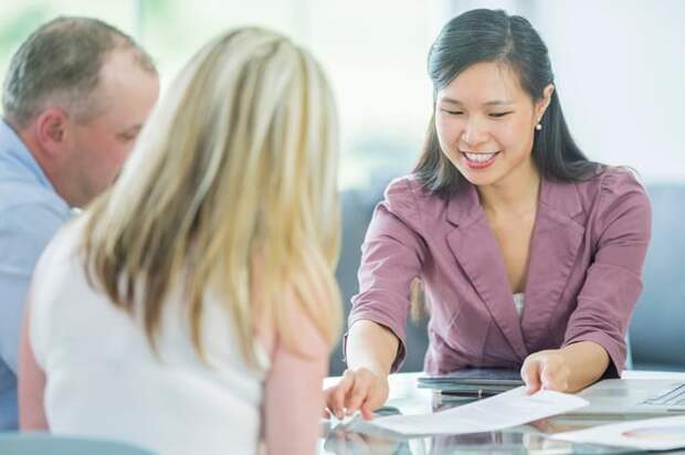 A couple look over loan documents with their loan officer.