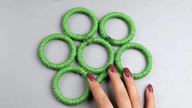 Соедините пластиковые кольца для карниза с джутом или пряжей, чтобы в результате получить стильную вещицу