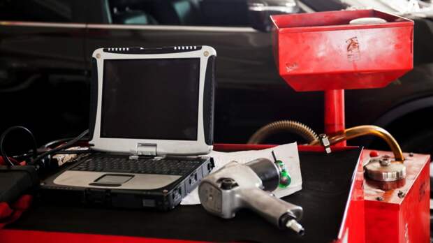 Diagnostic machine tools ready to be used with car in background