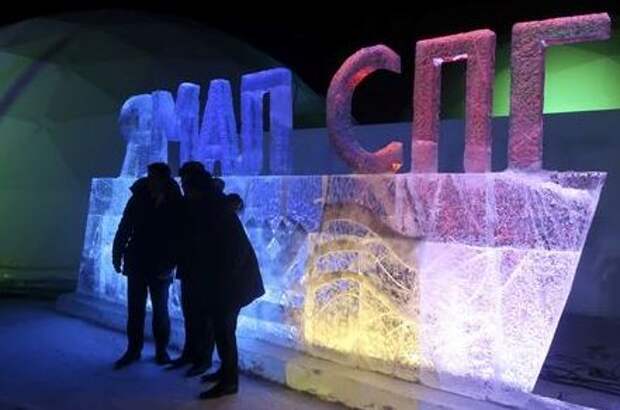People pose in front of an ice sculpture installation at Yamal LNG, Russia's second liquefied natural gas plant, which is under construction in the Arctic port of Sabetta, Yamalo-Nenets district, Russia December 8, 2017. The installation reads, "Yamal LNG". REUTERS/Oksana Kobzeva