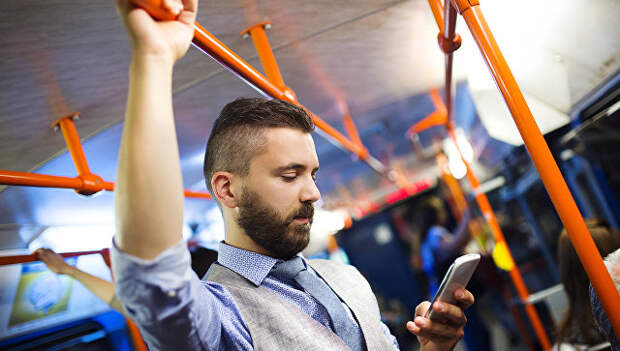 Пассажир в автобусе пользуется смартфоном. Архивное фото