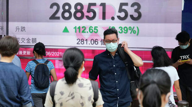 Люди в защитных масках проходят мимо табло с котировками ценных бумаг в Гонконге - РИА Новости, 1920, 16.06.2021