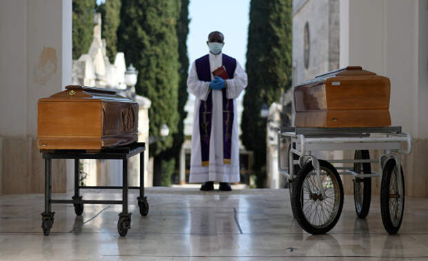 Священник и два гроба с жертвами коронавируса, Италия