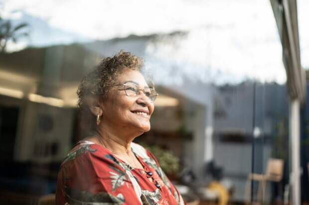 Person looking out a window and smiling.