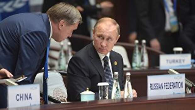 Владимир Путин и помощник президента Юрий Ушаков во время первого рабочего заседания глав делегаций государств-участников Группы двадцати
