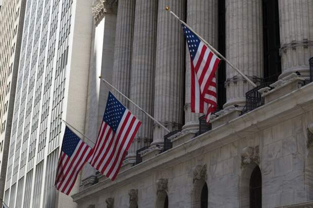 Front of New York Stock Exchange, with three U.S. flags hanging.