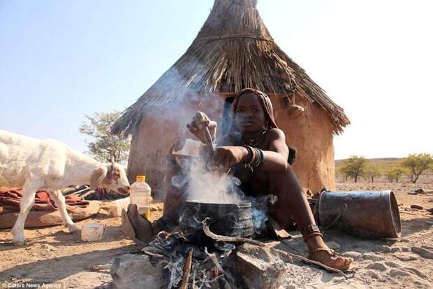 Молодая девушка из племени Химба готовит еду в живописной сельской местности Намибии африка, глобализация, намибия, племя