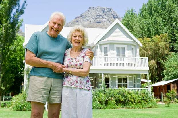 Two people standing in front of a house.