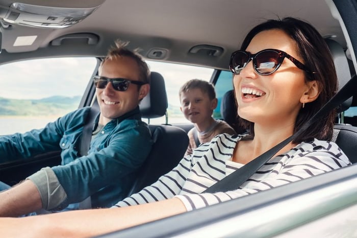 Family on a road trip with shades on and windows down.