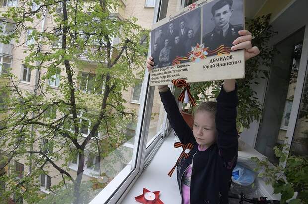 Девочка с портретами своих родственников - ветеранов Великой Отечественной войны, Москва.