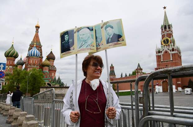 Женщина с портретами участников войны на Красной площади в Москве.