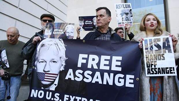 Люди стоят с баннерами Освободить Джулиана Ассанжа у Вестминстерского суда в Лондоне, где рассматривается дело основателя WikiLeaks Джулиана Ассанжа