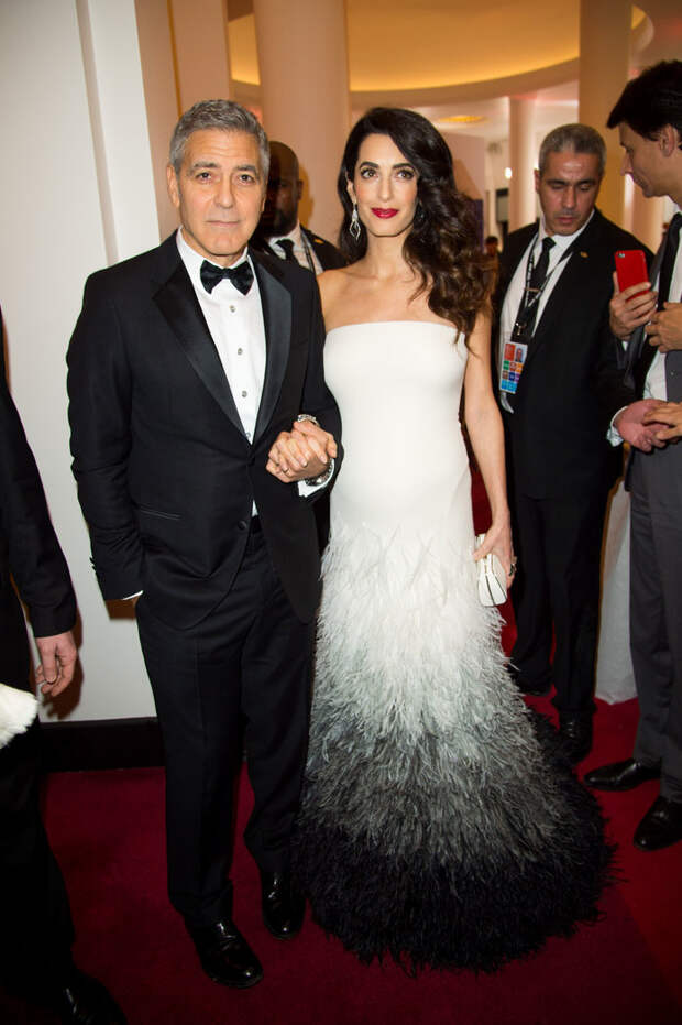 Амаль Клуни в вечернем платье с перьями, Джордж Клуни в черном смокинге