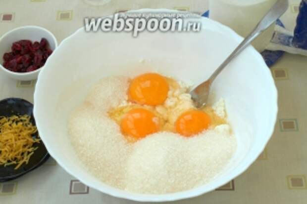 В глубокую миску выложить творог, разбить яйца и добавить сахар с ванилином. Хорошо растереть всю массу вилкой.