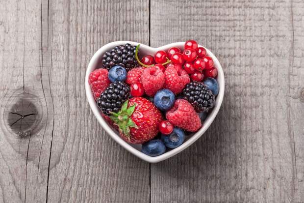 Berries-overhead-mix-in-heart-shaped-ceramic-jar-wooden-background