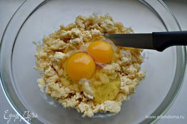 Просейте муку в охлаждённую миску. Кончиками пальцев перетрите муку и охлаждённое сливочное масло, пока смесь не превратится в мелкие крошки. Добавьте яйца, соль и сахар, вмешайте ножом.