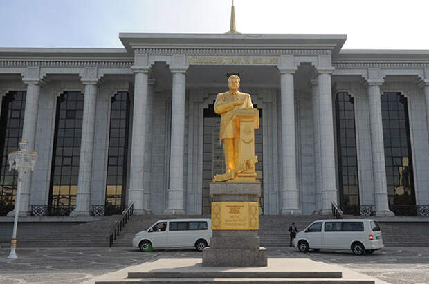 Здание Меджлиса Туркменистана в Ашхабаде. На первом плане - памятник первому президенту Туркменистана Сапармурату Ниязову.