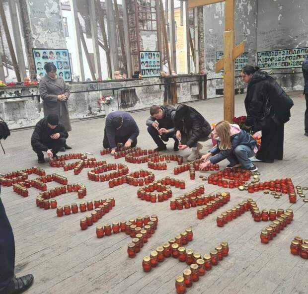 В разрушенном спортзале бесланской школы выложили свечами: «Москва. Скорбим. Беслан».