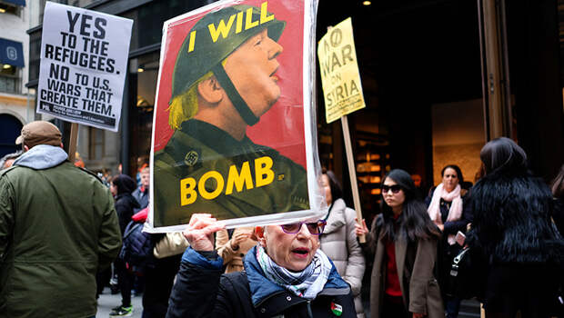 Протестующая с антитрамповским плакатом в Нью-Йорке