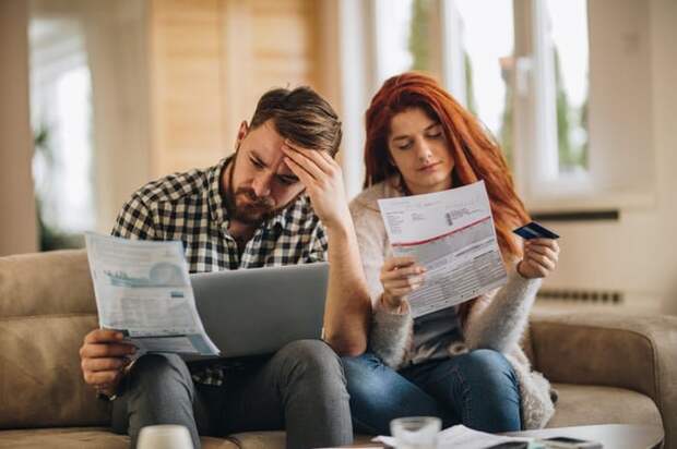 A worried couple looking at bills.