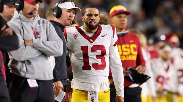 Caleb Williams speaks with head coach Lincoln Riley on the sidelines.