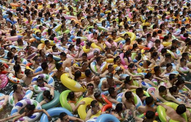 Посетители бассейна в уезде Даин (провинция Сычуань) задевают друг друга резиновыми кругами и не оставляют попыток расслабиться и отдохнуть. китай, люди, население