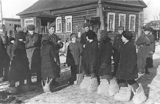 Школьники освобожденного Гжатска (Ныне — город Гагарин) показывают красноармейцам немецкие «эрзац-валенки». Смоленская область. Март 1943 г.