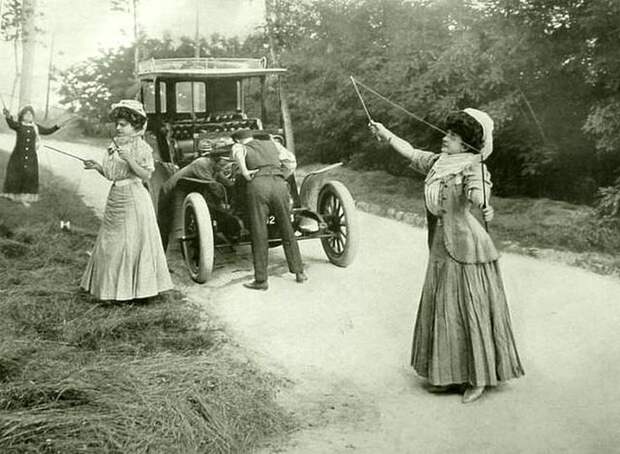 Три женщины играют с игрушками, а два мужчины пытаются исправить свою машину, Англия, 1908 год. ( С тех пор ничего не изменилось !!) история, черно-белая фотография, юмор