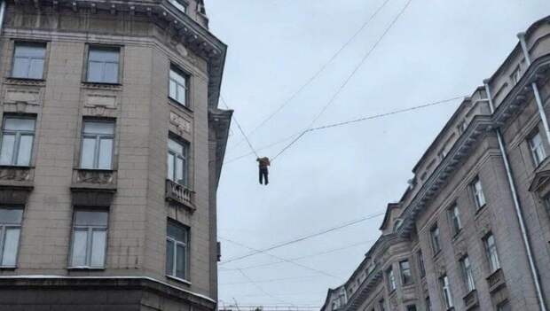 В Петербурге дворник сорвался с крыши дома и повис на проводах