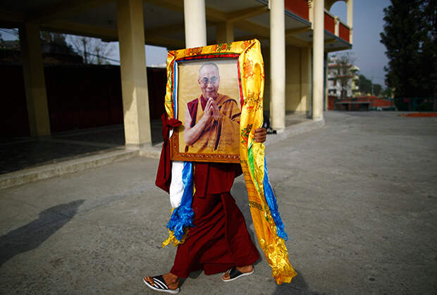 Тибетский монах несет портрет Далай-ламы XIV