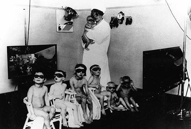 Медсестра и немецкие дети «расы господ», над которыми производят процедуры по осветлению волос и глаз