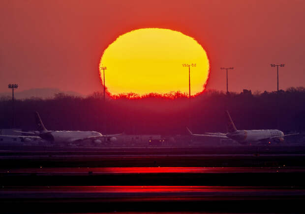 Припаркованные самолеты в аэропорту Франкфурта, Германия во время восхода солнца