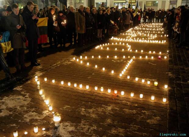 Люди зажгли свечи в память о жертвах обстрела украинского города Мариуполь недалеко от литовского парламента в Вильнюсе.