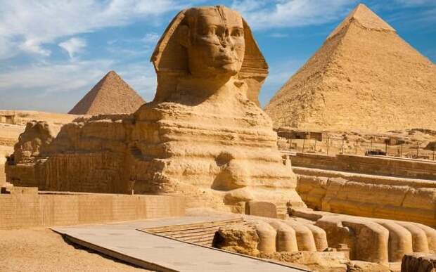 Большой Сфинкс среди пирамид. За кадром слева и справа начинаются густонаселенные пригороды Каира