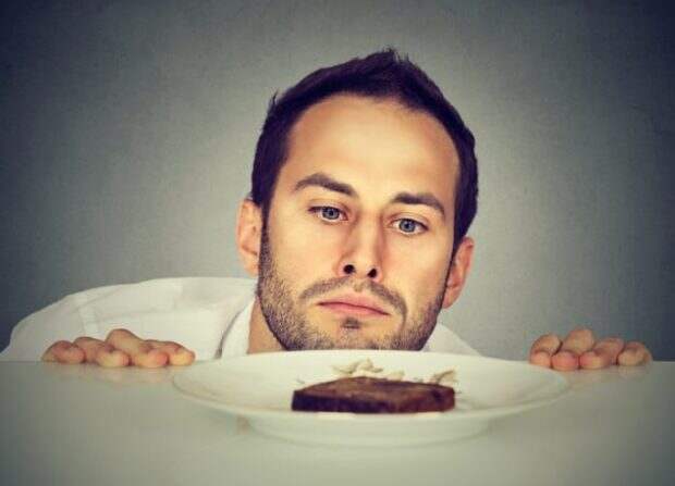 Мужчина смотрит на тарелку с едой