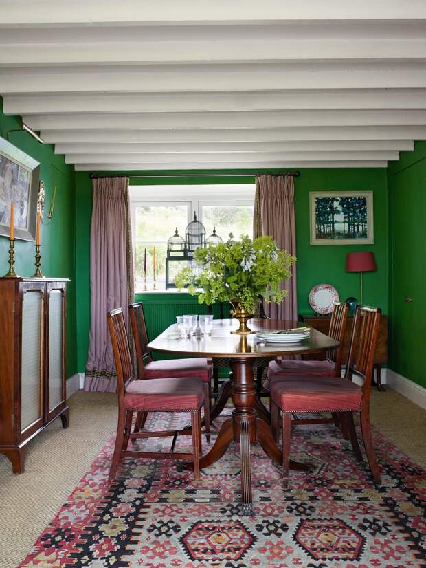 Килим (так называется ковер на полу) очень красиво сочетатся со стульями (ткань для них тоже была куплена на распродаже) и обеденным столом из темного дерева. А вот яркие зеленые стены — смелый поступок, я бы не решилась на такой насыщенный цвет
