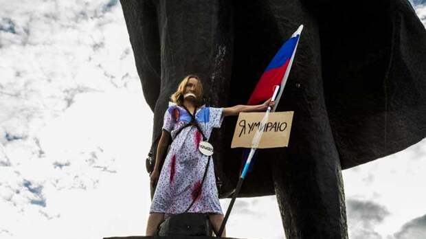 «Против нищеты и полицейского государства»: студентка в сорочке и с флагом РФ приковала себя к памятнику Ленину в Новосибирске