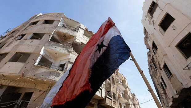 Сирийский флаг на разрушенной улице. Архивное фото