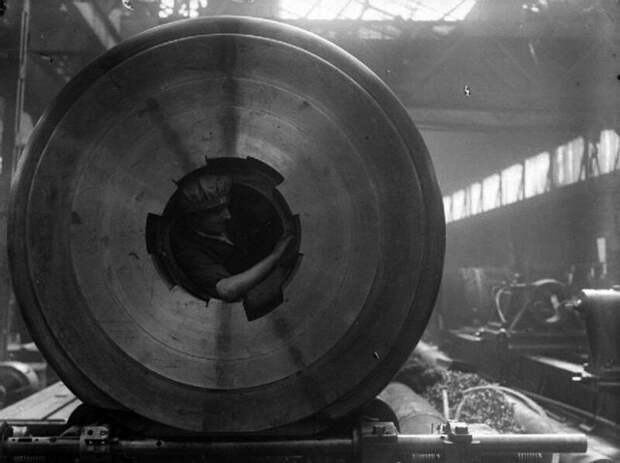 Женщина очищает нарезку 15-дюймовой корабельной пушки, находясь непосредственно в стволе, 1915 год. история, люди, мир, фото