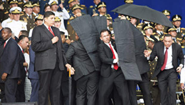 Сотрудники службы безопасности во время покушения на президента Венесуэлы Николаса Мадуро. 4 августа 2018