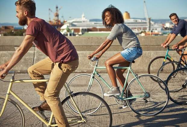 A group of friends riding bikes along the waterfront.