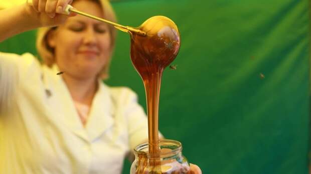 Женщина наливает мед в банку / Фото: amic.ru